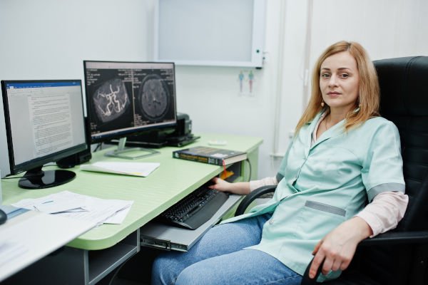 Lab assistant preparing MRI Brain Scan Report based on brain image
